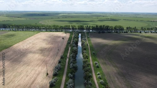 The car is moving on a dirt road. River junction, dam, fields. High quality aerial FullHD footage