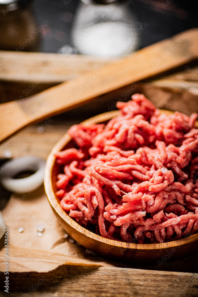 Minced meat on a wooden tray with onion rings. Minced meat on a wooden tray with onion rings.