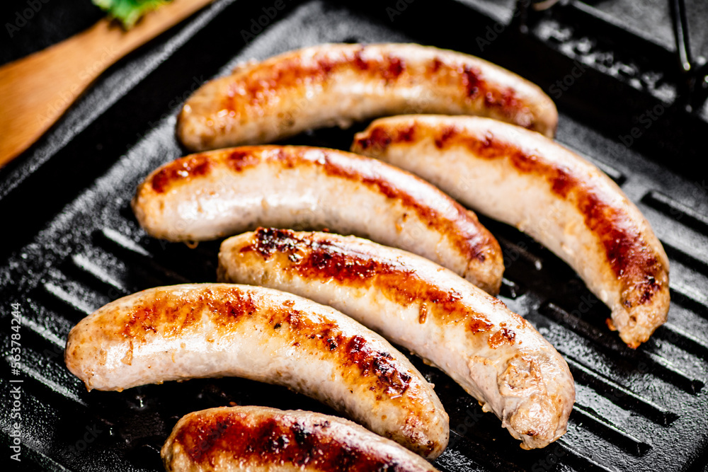 Grilled sausages in a frying pan. Grilled sausages in a frying pan.