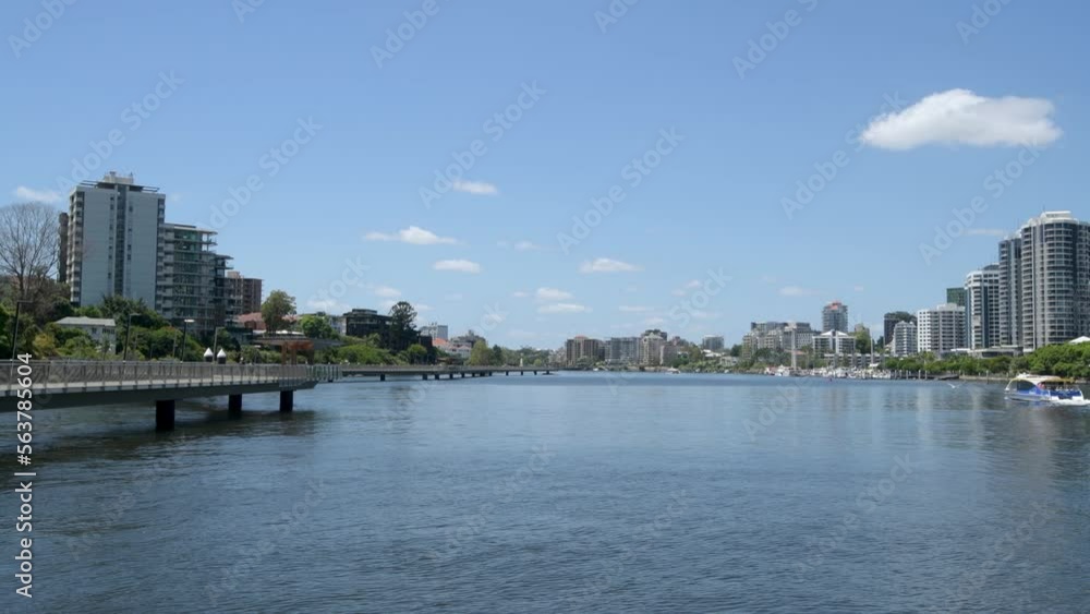 View down Brisbane River towards New Farm, people walking on the Riverwalk boardwalk and KittyCat ferry travelling down the river View down Brisbane River towards New Farm, people walking on the Riverwalk boardwalk and KittyCat ferry travelling down the river