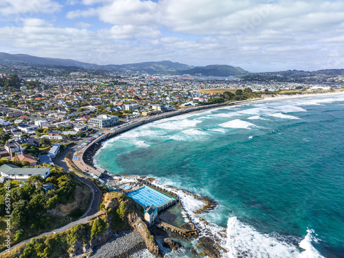 Beautiful high angle aerial drone view of a hot salt water pool in St Clair, a beachside suburb of Dunedin, the second-largest city in the South Island of New Zealand. Dunedin city in the background. photo