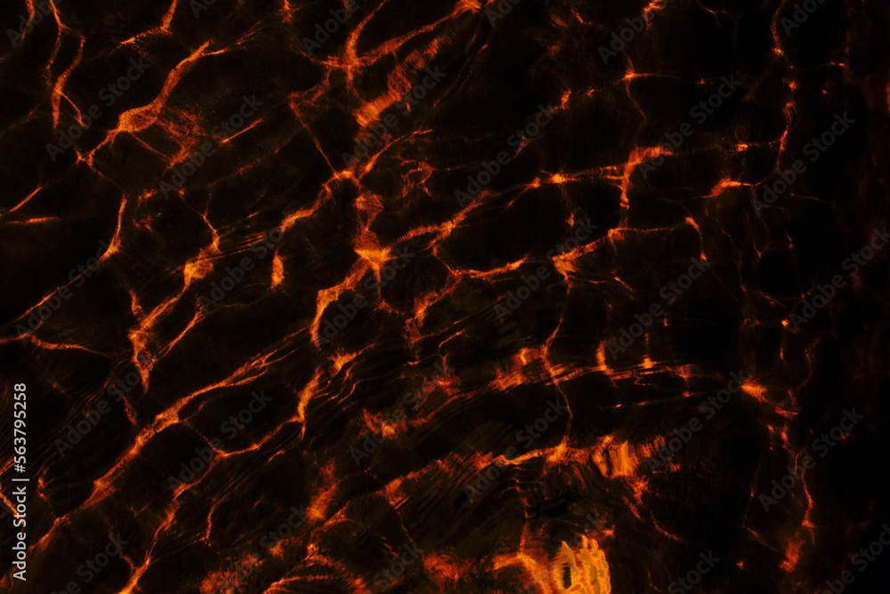 Abstract photo of the texture of light reflections from the surface of water waves in motion in dark red tones. Abstract photo of the texture of light reflections from the surface of water waves in motion in dark red tones.