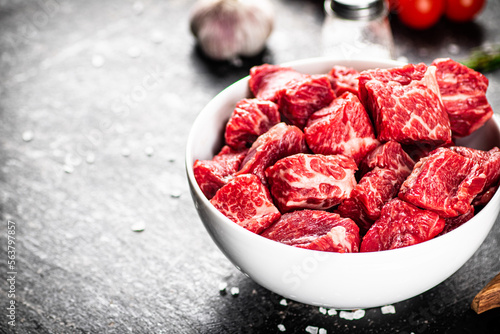 Sliced pieces of raw beef in a bowl.