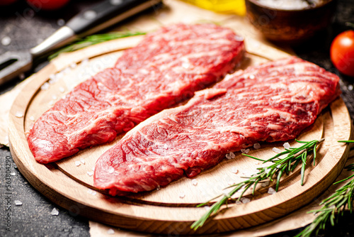 Raw steak on a wooden cutting board. 