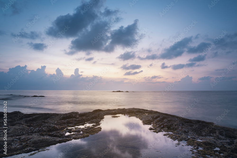 evening sunset on the sea. reflection of the sea in the water and coastal rocks, nang thong beach khao lak phuket thailand