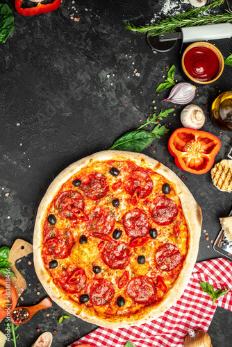 spicy pepperoni pizza, Tomato sauce, pepper, Italian pizza on dark table background. Restaurant menu, dieting, cookbook recipe top view