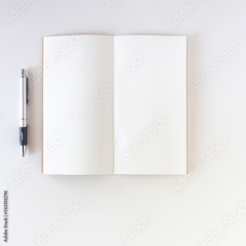 Open white blank on white background with pen. Travel notebook or sketchbook. © inspiredbyart