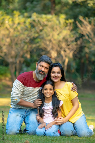 Happy indian couple with his little daughter at park.