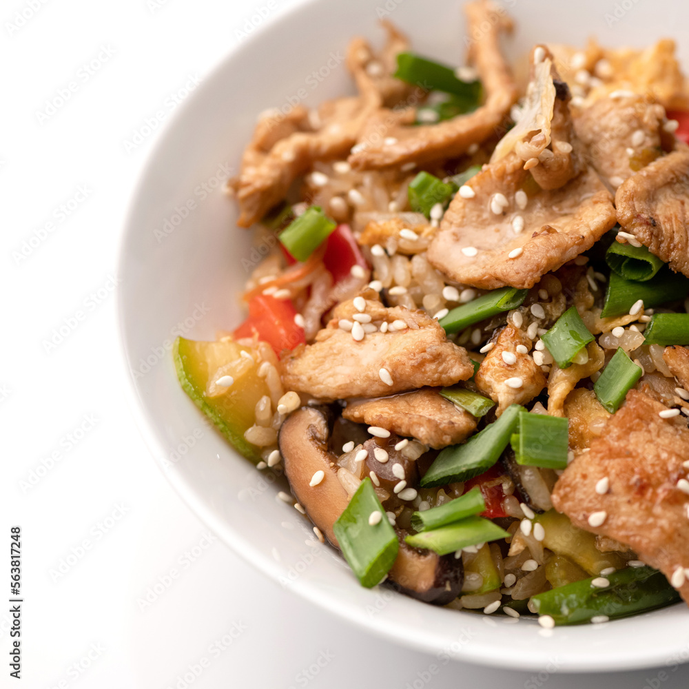 Udon noodles with chicken teriyaki, mushrooms, vegetables and sesame seeds. Asian cuisine. Dish on white background. Close-up. Udon noodles with chicken teriyaki, mushrooms, vegetables and sesame seeds. Asian cuisine. Dish on white background. Close-up.