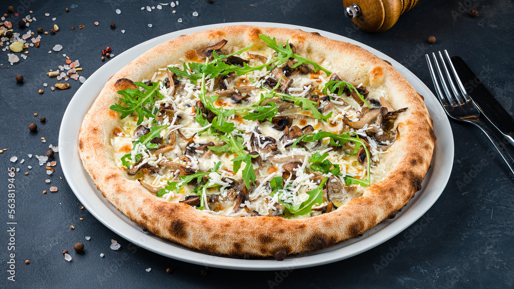 Italian pizza with mushrooms, goat cheese, parmesan and arugula on a thick dough with spices.