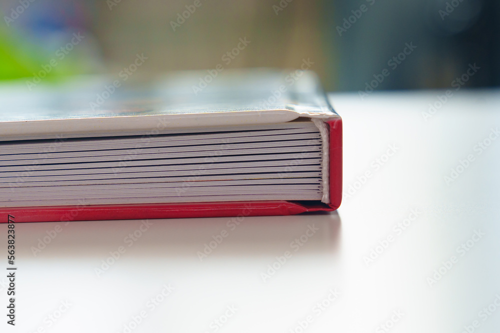 the binding of a photobook with plastic pages on a white table. 