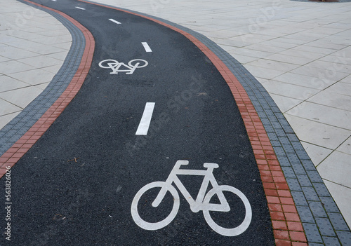 Billede på lærred promenade for pedestrians and cyclists with a dividing island between the lanes and road, road markings sprayed with paint on asphalt