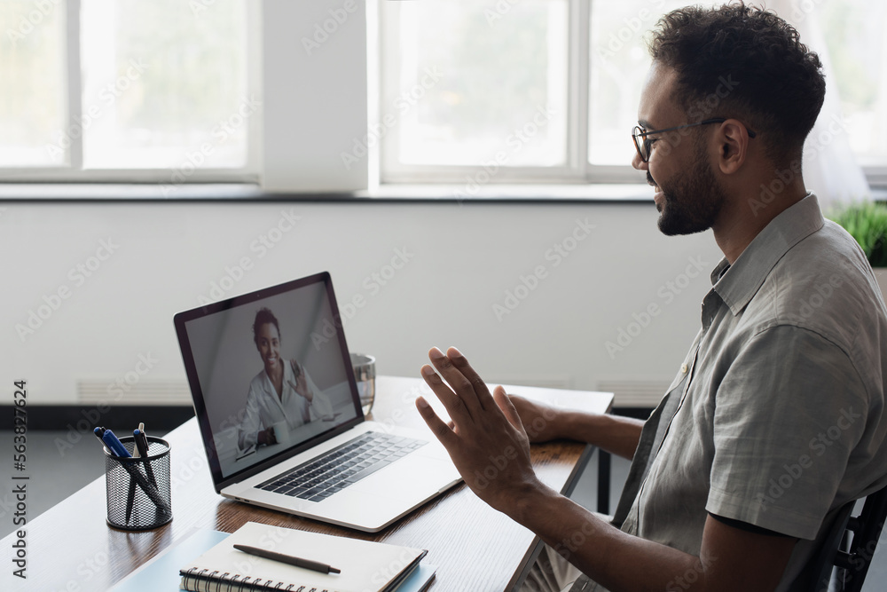 Smiling black man has video call conference with his remote teammate, Young student men learning online, Businessman working on laptop computer indoors, online business meeting concept Smiling black man has video call conference with his remote teammate, Young student men learning online, Businessman working on laptop computer indoors, online business meeting concept