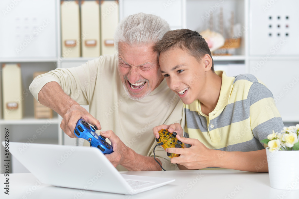 boy and grandfather playing computer game boy and grandfather playing computer game