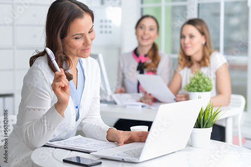 young women sit at the table and work in a modern office