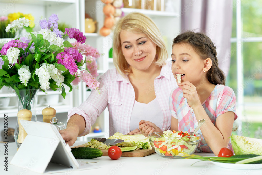 Cute little girl with her mother cooking together Cute little girl with her mother cooking together
