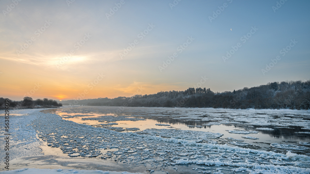 Amazing cold winter morning in Europe. Ice floes floating on a river. Amazing morning sunshine in extreme cold.