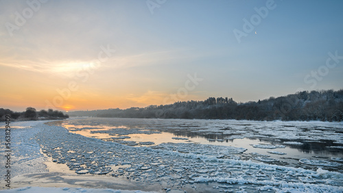 Obraz na płótnie Amazing cold winter morning in Europe. Ice floes floating on a river. Amazing morning sunshine in extreme cold. w salonie