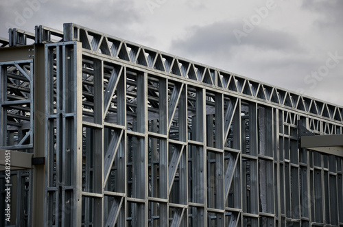 Building construction from metal trusses. lattice structure of the frame of an industrial building. A large thick tangle on the ceiling of a building under construction. shiny metal profiles steel,