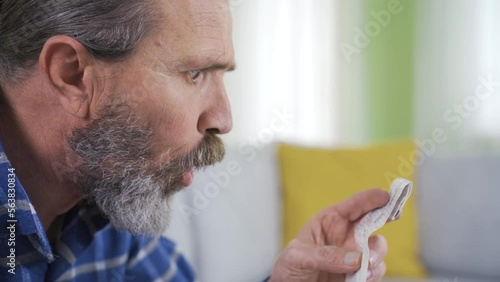 Confused old man looking at overpriced bill.
The price written on the receipt or the invoice in her hand surprises the woman and she thinks it is expensive.
