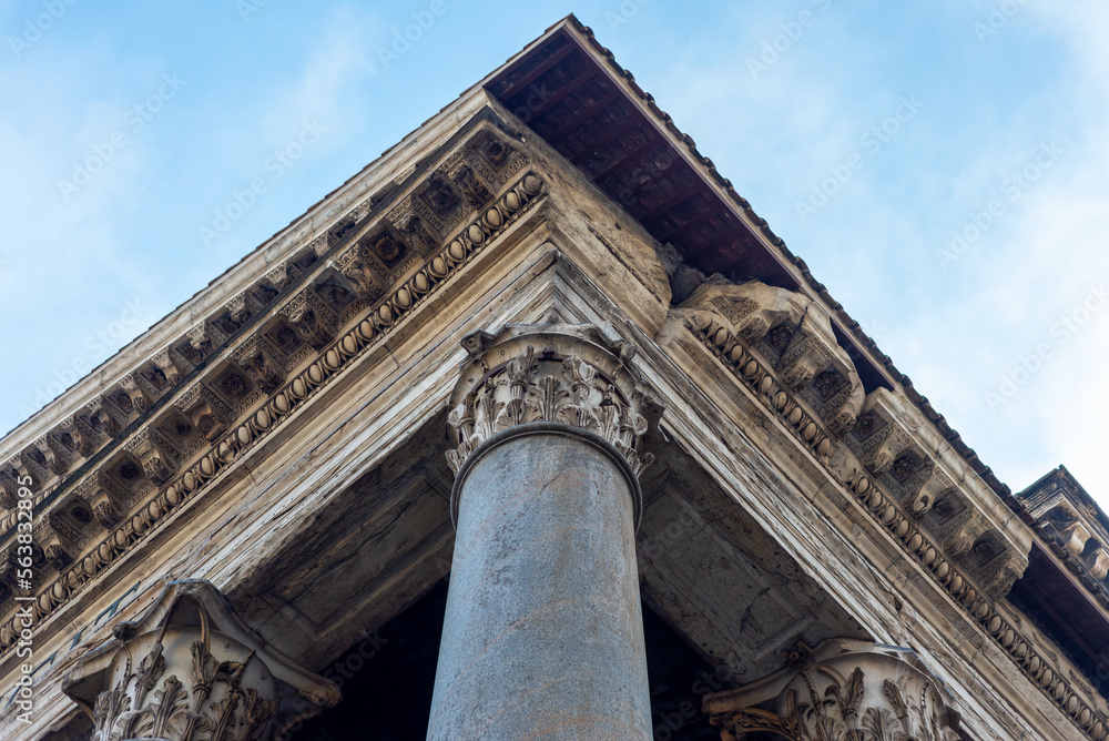 Fragment of columns and roof in Rome, in the blue sky. Important ancient buildings, fragment of the Temple.