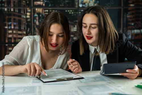 two young business woman accounting us tax 1040 form at office