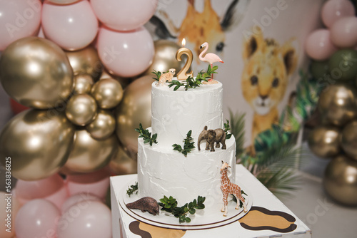 Animal themed birthday cake. Number 2 birthday candle in a cake. Two Tier Beautiful Animal Cake - flamingo, giraffe, leopard. Happy two years.