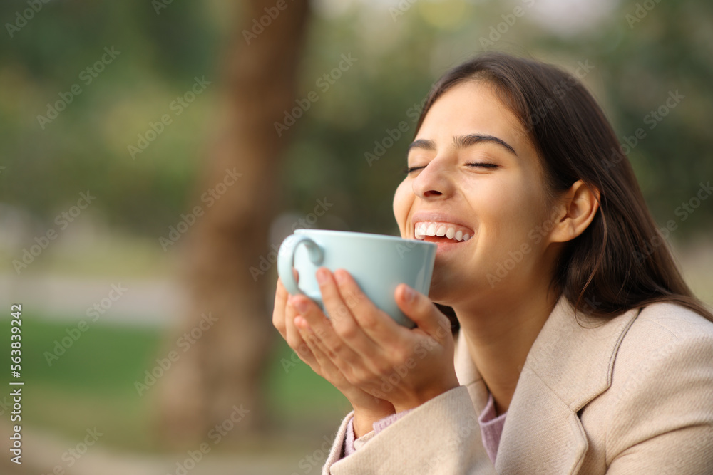 Happy woman in winter enjoying coffee Happy woman in winter enjoying coffee