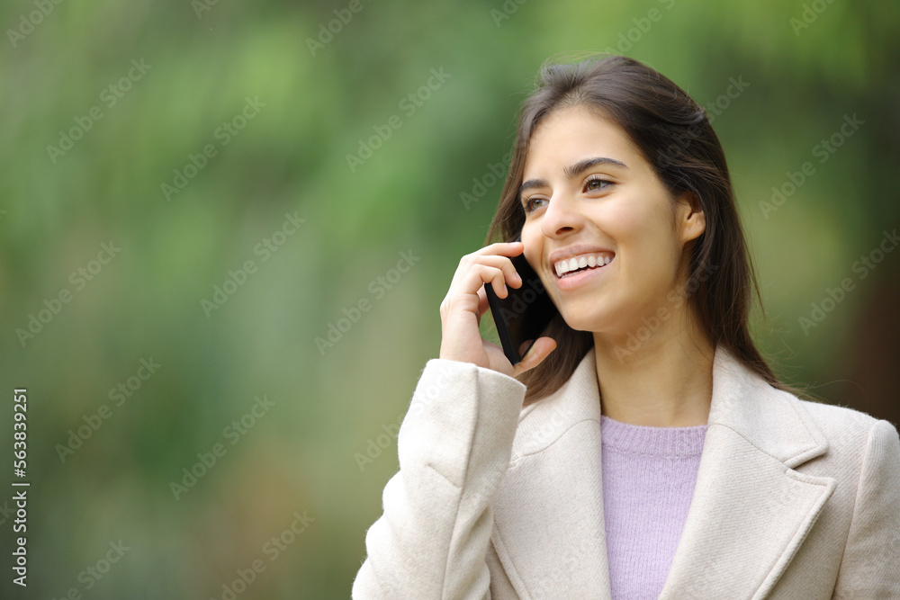 Happy woman in winter talks on smart phone Happy woman in winter talks on smart phone