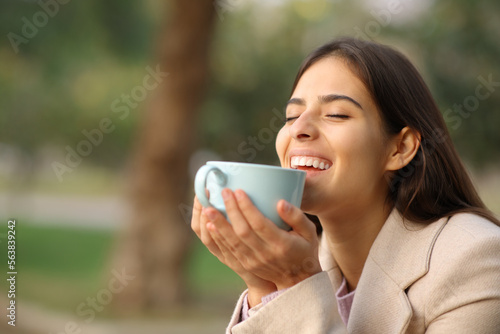 Happy woman in winter enjoying coffee