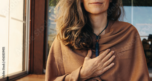 Fotografie Mature woman wearing a crystal necklace at home