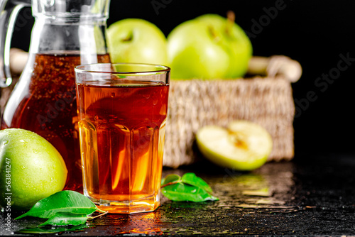 Apple juice in a jug and a glass on the table. 