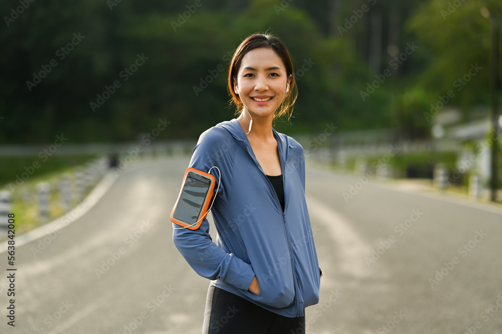 Gorgeous sporty woman taking a break during workout in the park. Healthy lifestyle, workout and wellness concept
