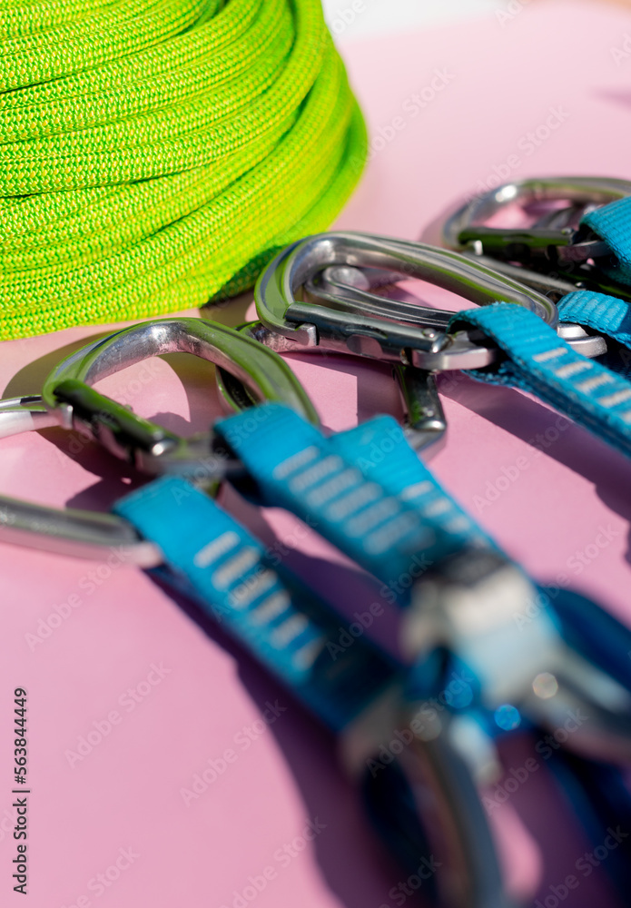 green rope and climbing and mountaineering equipment lies on a colored background. background image of rope and equipment for active sports. green rope and climbing and mountaineering equipment lies on a colored background. background image of rope and equipment for active sports.
