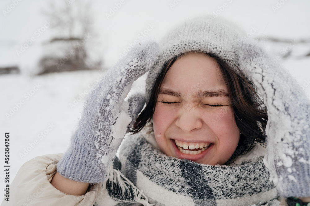 Cheerful teenage girl wearing knit hat enjoying in winter Cheerful teenage girl wearing knit hat enjoying in winter