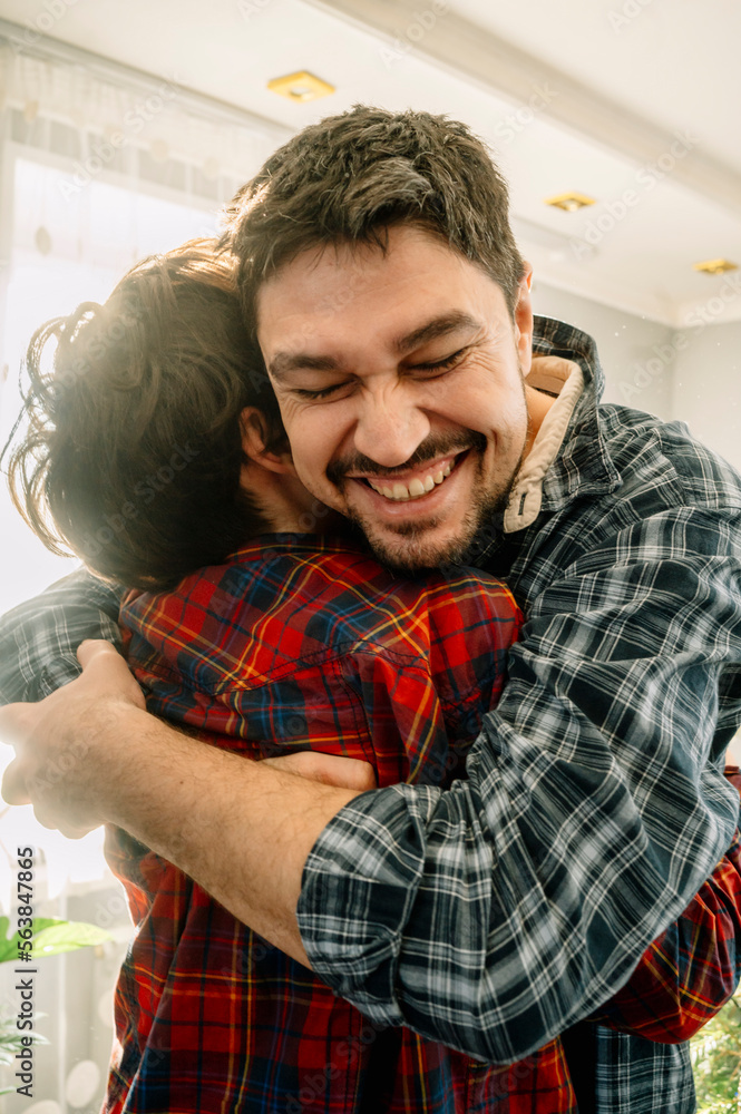 Cheerful father hugging son at home Cheerful father hugging son at home