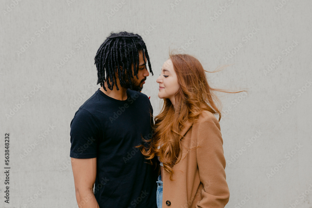 Young man standing with woman in front of wall Young man standing with woman in front of wall