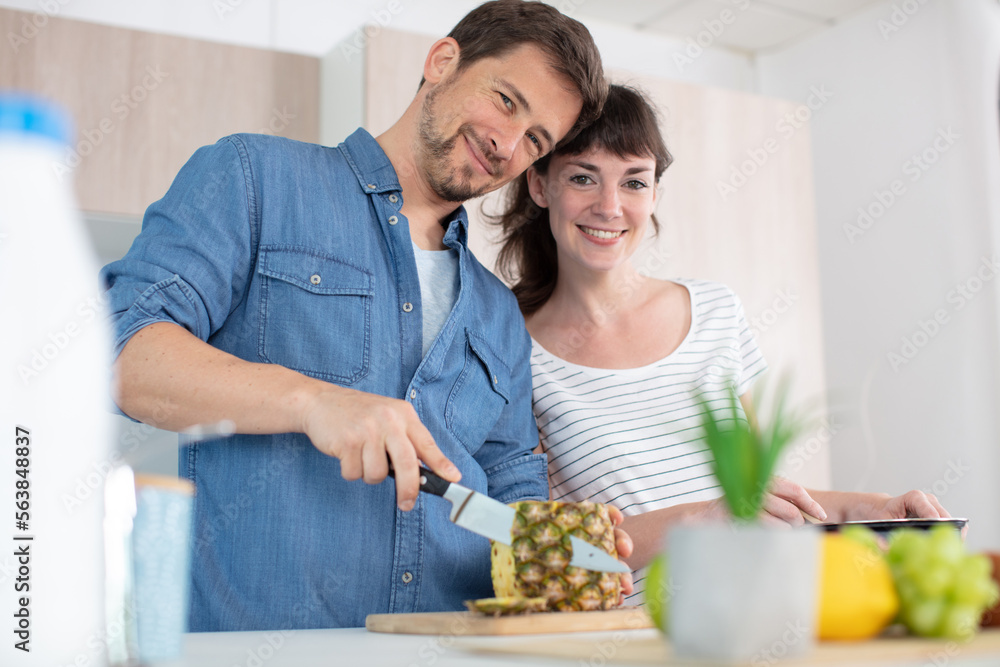 smiling couple preparing fruit in the kitchen