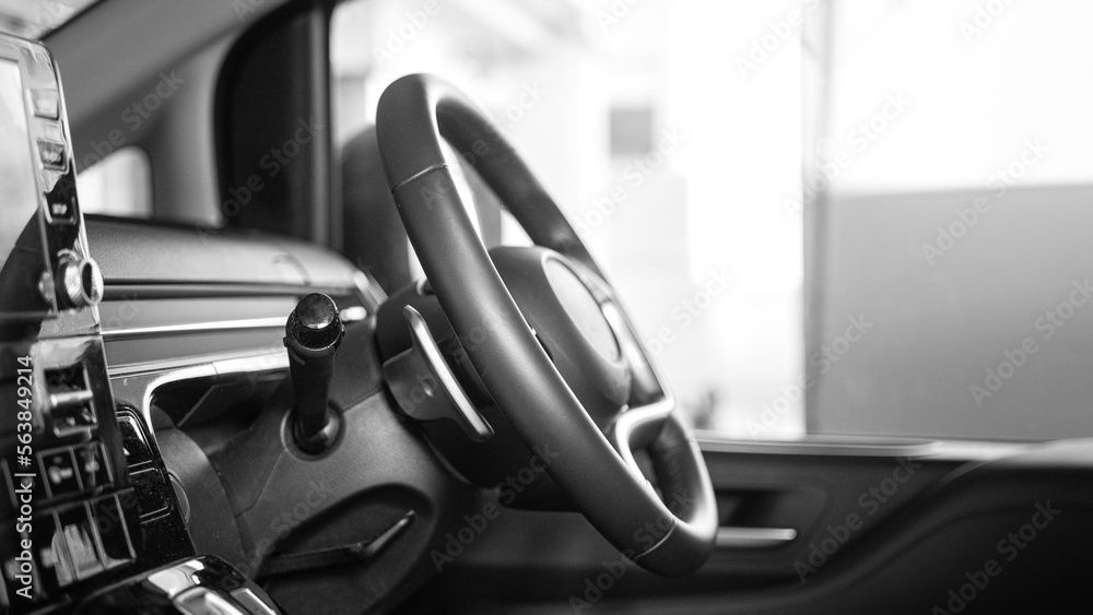 Obraz premium Close-up at steering wheel and controlling dashboard of the modern design car, ready for driving concept. Transportation equipment object, selective focus.