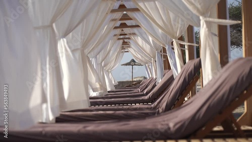 Luxury lounge with sun chair and white curtains on the beach. Vacation and relaxation concept 