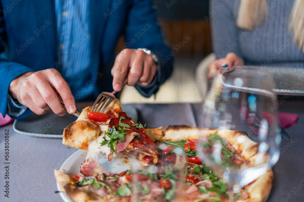 A close-up shot of a dish served at a restaurant for dinner. in the frame are hands and an escajg.