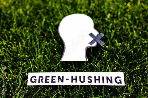 green-hushing companies staying silent about their environmental policies, text and face with mouth shut on green grass
