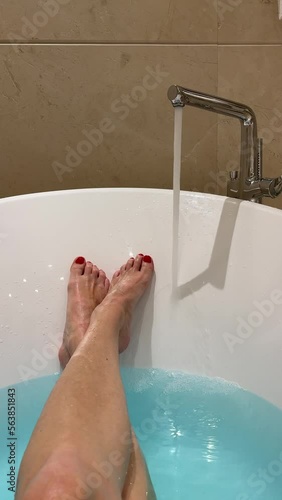 HD , woman's legs in a bathroom of hotel. hot water pours into the bath.