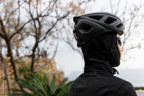 portrait of a cyclist in a helmet and mask stands with his back. biker portrait.