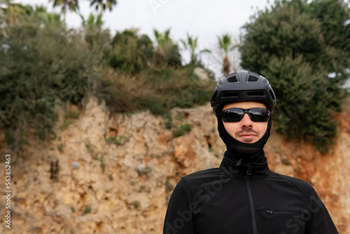 portrait of a cyclist in a helmet, goggles and a protective mask close-up. portrait of a smiling biker looking at the camera. complete cyclist outfit. © Juli Puli