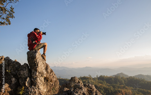 Man holding camera in his hands and making photos of the mountains during autumn morning, Hiking and tourism concepts