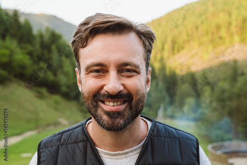 Bearded white man walking in green forest during vacation