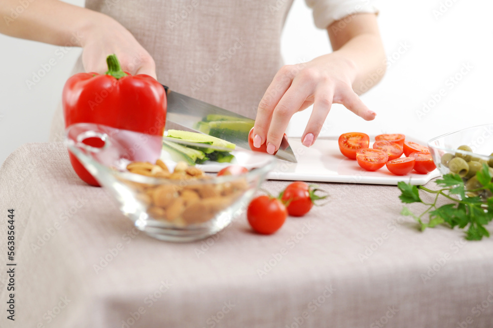 close-up on the table glass plate with nuts almonds tomatoes and bell peppers on background female hands cut cucumber healthy vegetarian food restaurant at home in cafe tasty fresh vegetables close-up on the table glass plate with nuts almonds tomatoes and bell peppers on background female hands cut cucumber healthy vegetarian food restaurant at home in cafe tasty fresh vegetables