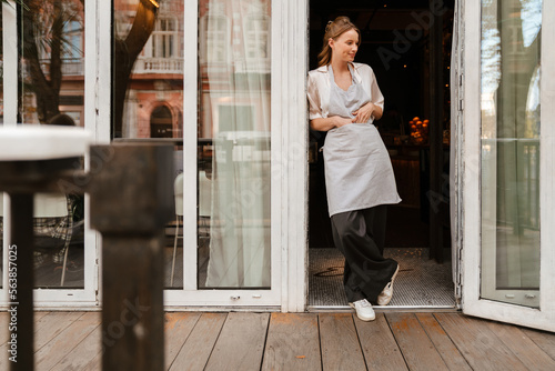 Young white waitress woman wearing apron smiling while working in cafe © Drobot Dean