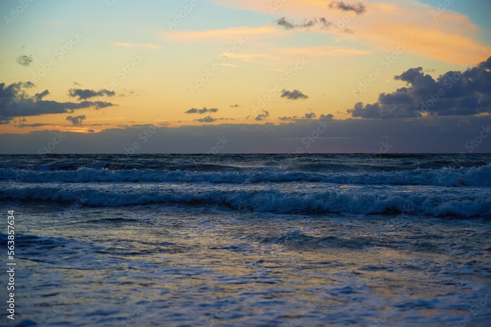 Obraz premium Panoramic view of sea landscape against sunset. Baltic sea coastline with waves and beautiful cloudy sky
